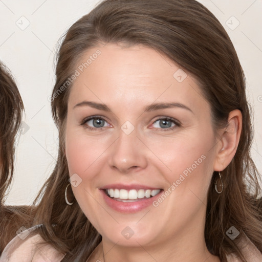 Joyful white young-adult female with long  brown hair and blue eyes