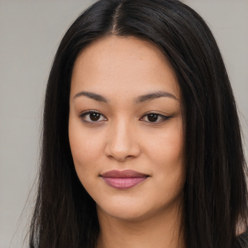 Joyful asian young-adult female with long  brown hair and brown eyes