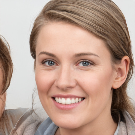 Joyful white young-adult female with medium  brown hair and blue eyes