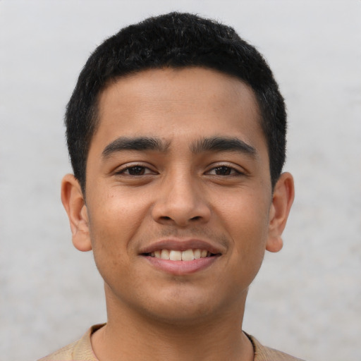 Joyful latino young-adult male with short  black hair and brown eyes