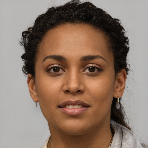 Joyful black young-adult female with short  brown hair and brown eyes