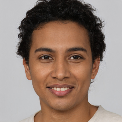 Joyful latino young-adult male with short  brown hair and brown eyes