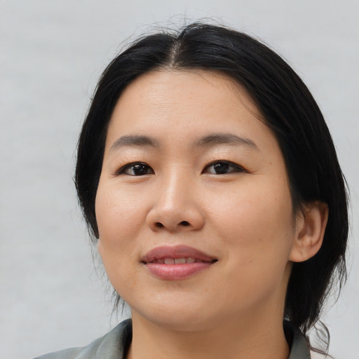 Joyful asian young-adult female with medium  black hair and brown eyes