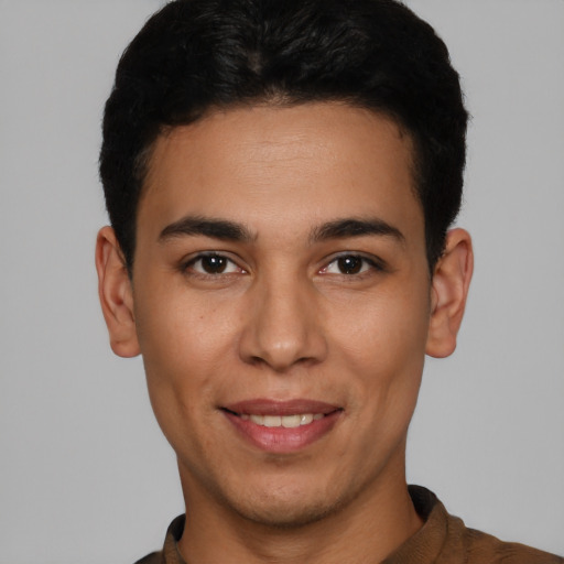 Joyful latino young-adult male with short  black hair and brown eyes