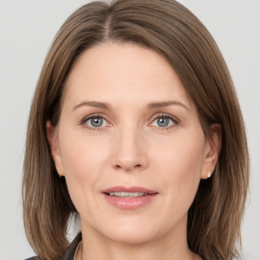 Joyful white adult female with medium  brown hair and grey eyes