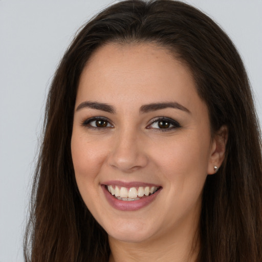 Joyful white young-adult female with long  brown hair and brown eyes