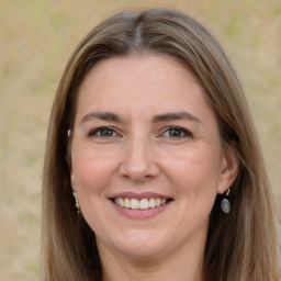 Joyful white adult female with long  brown hair and grey eyes