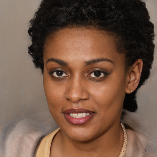 Joyful black young-adult female with short  brown hair and brown eyes