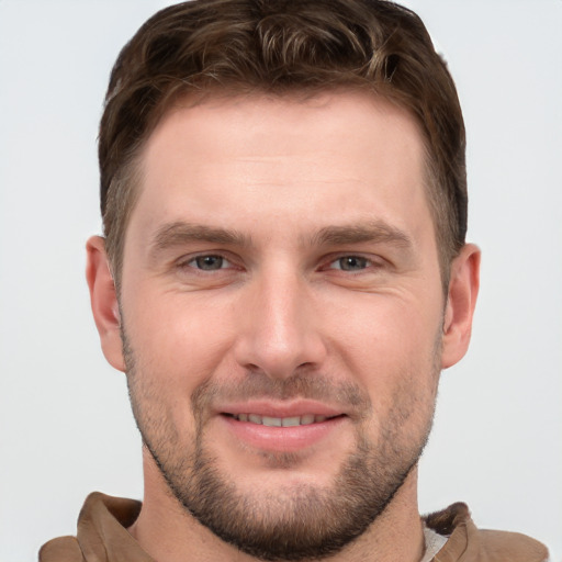 Joyful white young-adult male with short  brown hair and grey eyes