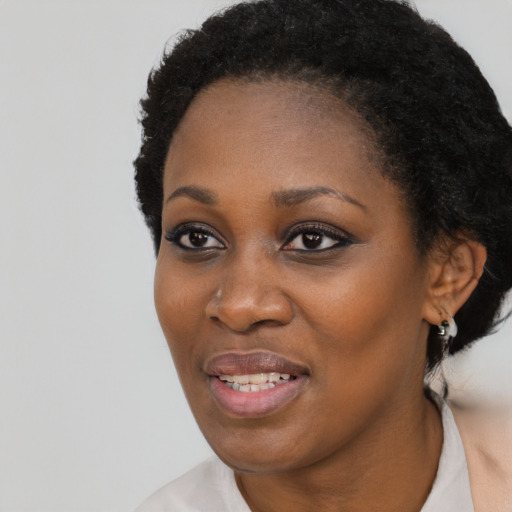 Joyful black young-adult female with short  black hair and brown eyes
