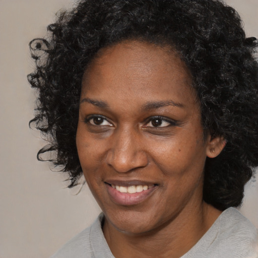 Joyful black adult female with short  black hair and brown eyes