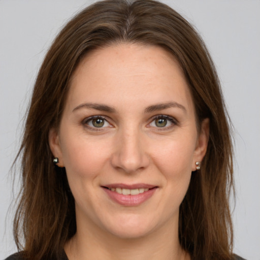 Joyful white young-adult female with long  brown hair and green eyes