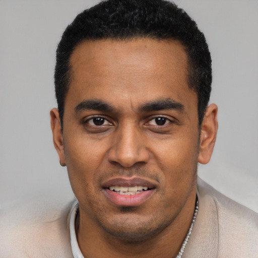 Joyful black young-adult male with short  black hair and brown eyes