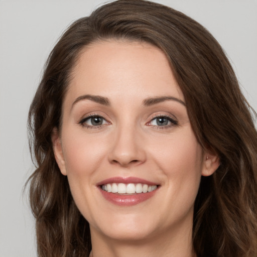 Joyful white young-adult female with long  brown hair and grey eyes