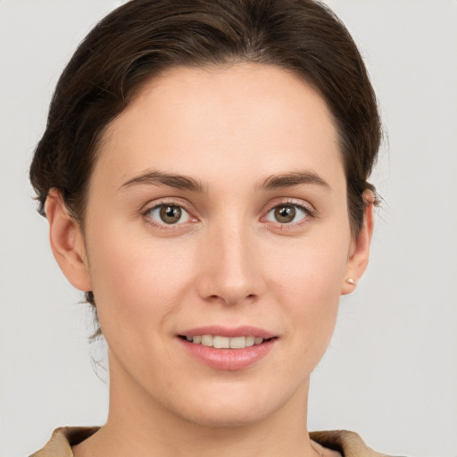 Joyful white young-adult female with short  brown hair and grey eyes