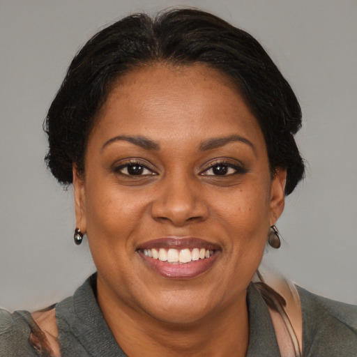 Joyful black adult female with medium  brown hair and brown eyes