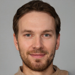 Joyful white young-adult male with short  brown hair and grey eyes