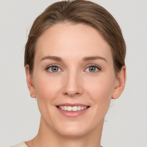 Joyful white young-adult female with short  brown hair and grey eyes