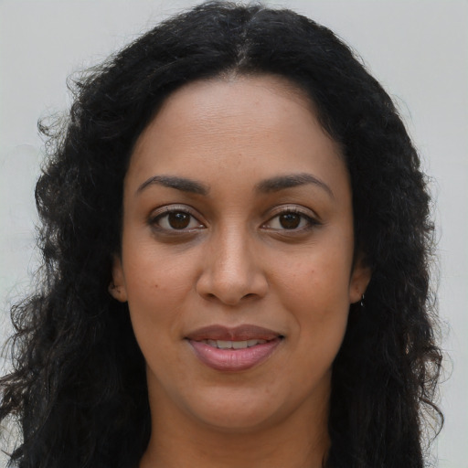 Joyful latino young-adult female with long  brown hair and brown eyes