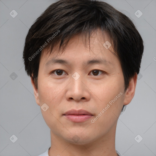 Joyful asian young-adult male with short  brown hair and brown eyes