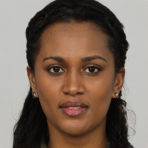 Joyful black young-adult female with long  brown hair and brown eyes