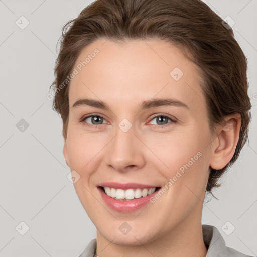 Joyful white young-adult female with short  brown hair and grey eyes