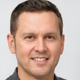 Joyful white adult male with short  brown hair and brown eyes