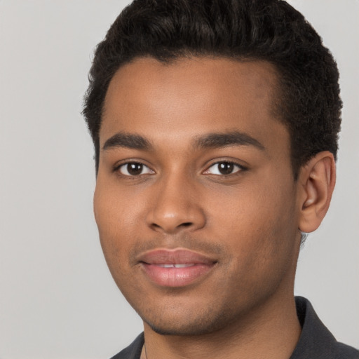 Joyful black young-adult male with short  brown hair and brown eyes