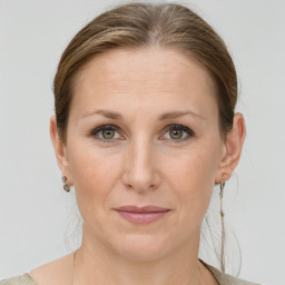 Joyful white adult female with medium  brown hair and grey eyes