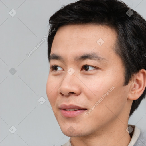 Joyful asian young-adult male with short  black hair and brown eyes