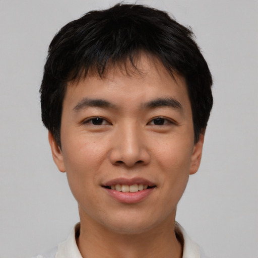 Joyful asian young-adult male with short  black hair and brown eyes