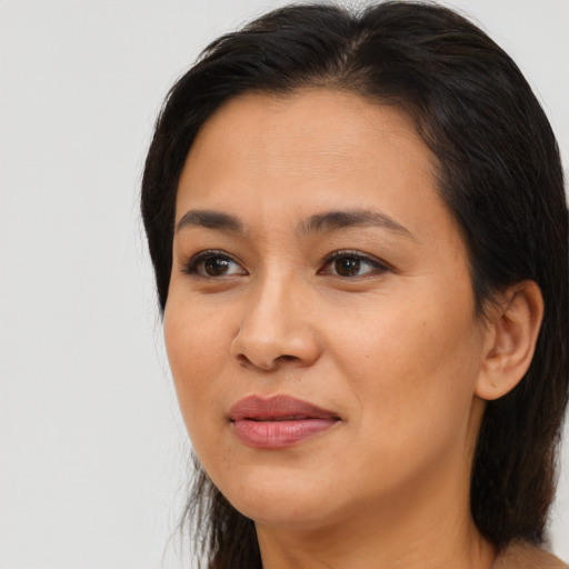 Joyful asian adult female with long  brown hair and brown eyes