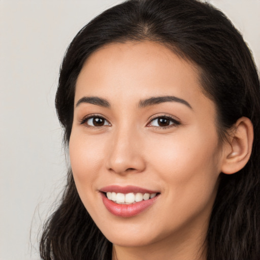 Joyful latino young-adult female with long  brown hair and brown eyes