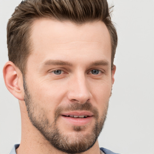 Joyful white young-adult male with short  brown hair and grey eyes