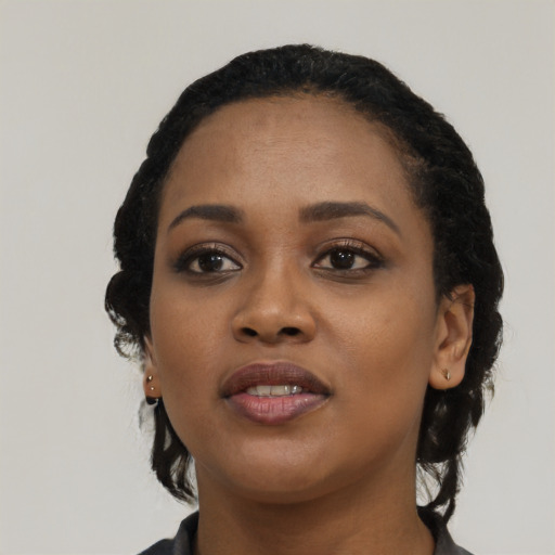 Joyful black young-adult female with long  black hair and brown eyes