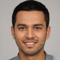 Joyful white young-adult male with short  black hair and brown eyes