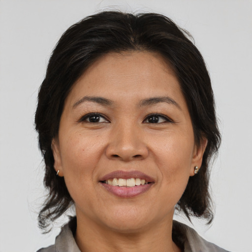 Joyful asian adult female with medium  brown hair and brown eyes