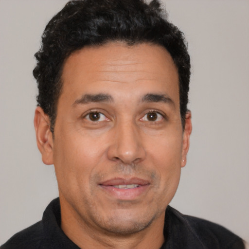 Joyful latino adult male with short  black hair and brown eyes