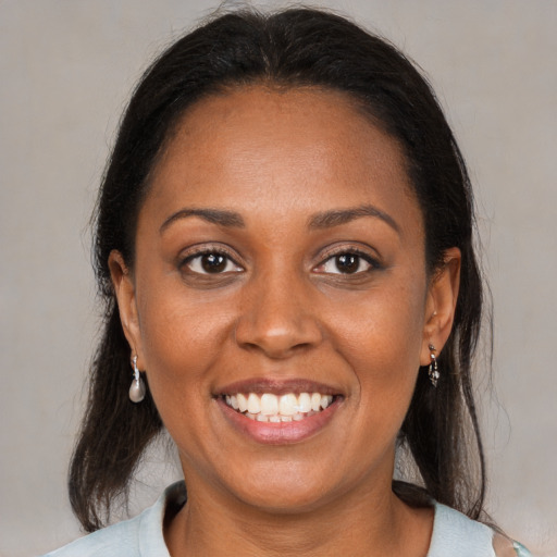 Joyful black young-adult female with medium  brown hair and brown eyes