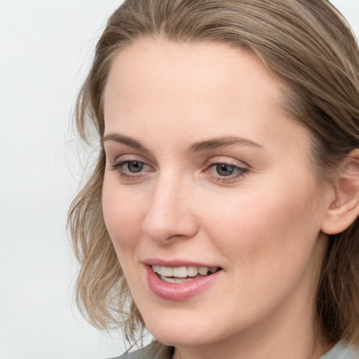 Joyful white young-adult female with medium  brown hair and blue eyes