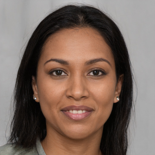 Joyful black young-adult female with long  brown hair and brown eyes