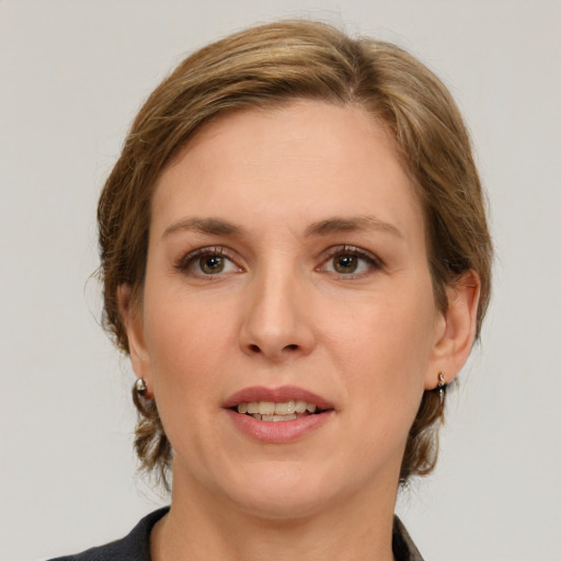 Joyful white young-adult female with medium  brown hair and grey eyes