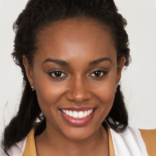 Joyful black young-adult female with long  brown hair and brown eyes