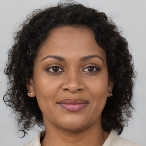 Joyful black young-adult female with long  brown hair and brown eyes