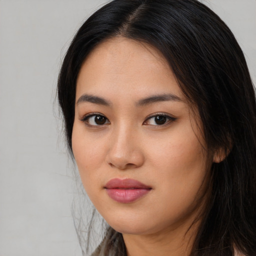 Joyful asian young-adult female with long  brown hair and brown eyes