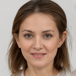 Joyful white young-adult female with medium  brown hair and grey eyes