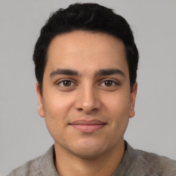 Joyful latino young-adult male with short  black hair and brown eyes