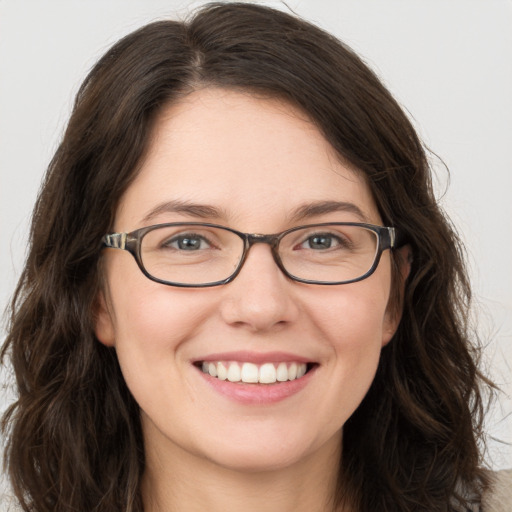 Joyful white young-adult female with long  brown hair and green eyes