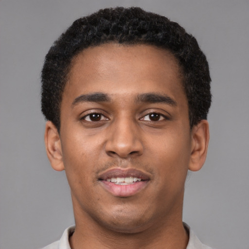 Joyful black young-adult male with short  brown hair and brown eyes