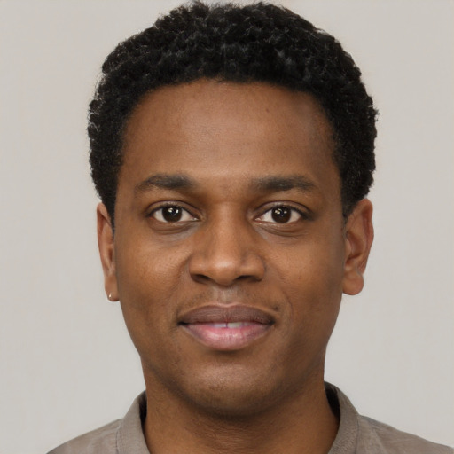 Joyful black young-adult male with short  black hair and brown eyes